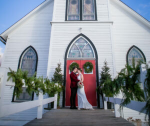 couple poses outside of church after wedding